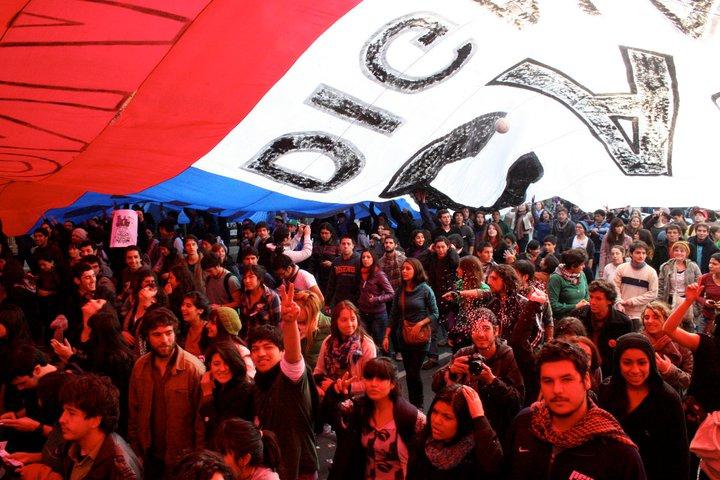 Demonstranten unter einer riesigen chilenischen Flagge