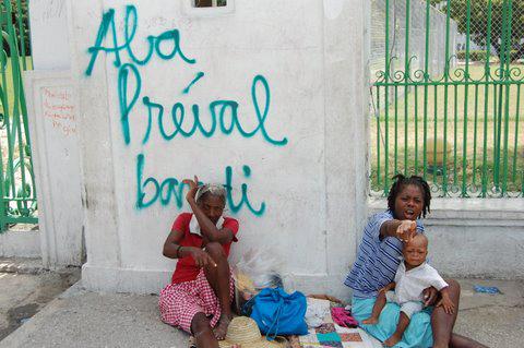 Vor dem Nationalpalast warten ganze Familien auf Touristen, die die Ruinen sehen möchten. Hinter ihnen steht an "Nieder mit Préval". Gemeint ist der Präsident René Preval.

Juni 2010, Port-au-Prince, Haiti
