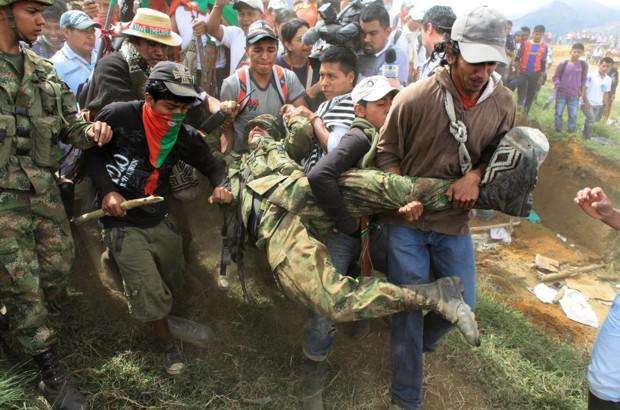 Indigene Demonstranten tragen Soldaten vom Militärstützpunkt Las Torres