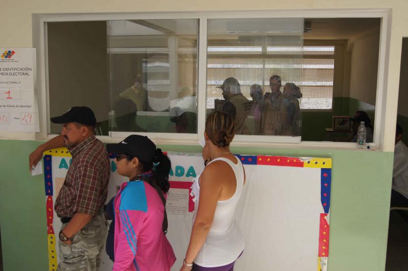 Wählerinnen und Wähler warten vor dem Wahlbüro in einer Schule in Ciudad Caribia