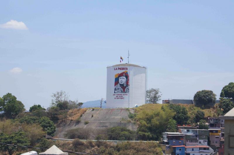 Mitglieder des Kollektivs La Piedrita haben an einem Wasserspeicher über dem Stadtteil 23 de Enero ein Bild von Hugo Chávez angebracht.