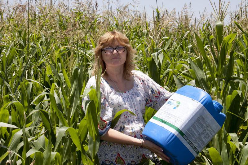 Aktivistin mit einem Glyphosat-Behälter in einem Maisfeld in Argentinien