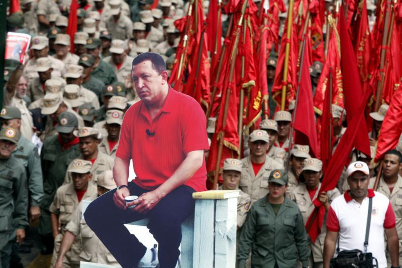 Ein Demonstrationsteilnehmer trägt eine Installation mit dem Bild des verstorbenen Präsidenten Hugo Chávez