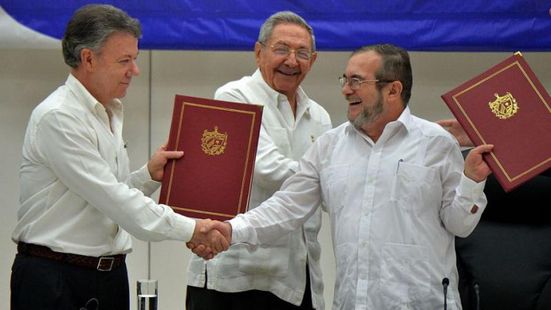 Präsident Santos und der Farc-Oberkommandierende Timoleón Jiménez nach Unterzeichung des Abkommens. Hinter ihnen Kubas Präsident Raúl Castro