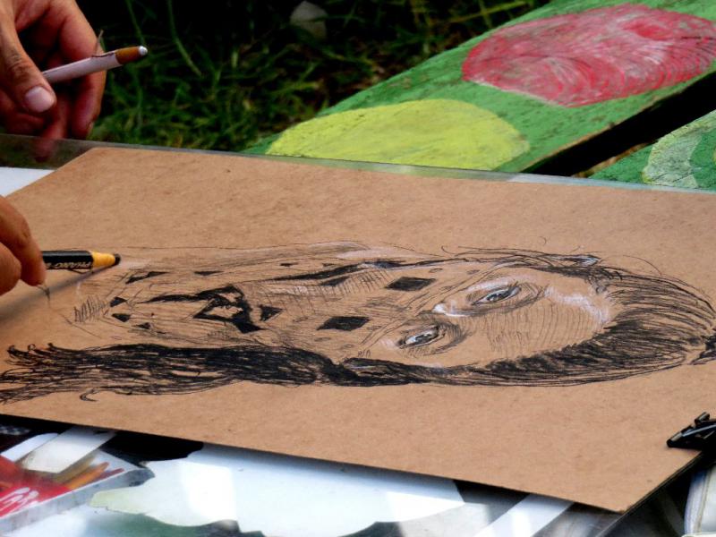 Yu, ein Künstler aus Japan malte bei dem Festival Porträts von Leuten mit einem Halstuch, das das Gesicht halb verdeckt und somit an das auftreten der Zapatisten erinnert