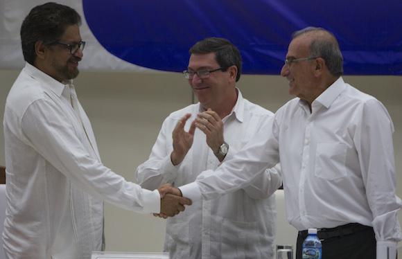 Handschlag nach Unterzeichnung des Abkommens: Die Leiter der Friedensdelegationen der Farc, Iván Marquez (links), und der Regierung, Humberto de la Calle (rechts). Beifall von Kubas Außenminister Bruno Rodríguez Parilla (hinten im Bild).