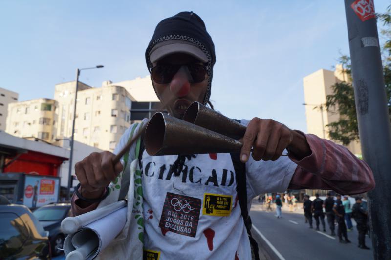 Ein Demonstrant weist auf soziale Verdrängung durch die Olympischen Spiele hin.