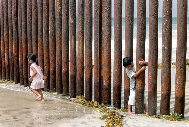 Kinder schlüpfen durch eine Grenzbefestigung zwischen den USA und Mexiko