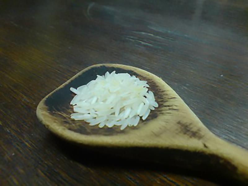 Ein Holzlöffel mit Reiskörner