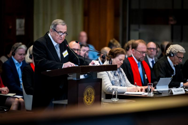 Carlos Argüello bei der Anhörung in Den Haag. Rechts von ihm die deutsche Delegation