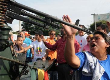Frauen stehen nach dem Putsch in Honduras Militärs gegenüber
