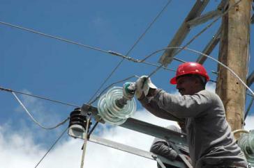 Arbeiter repariert Stromleitung in Kuba