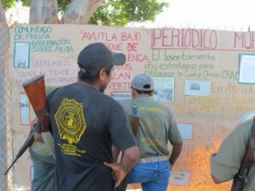 Aktivisten der CRAC vor einer Wandzeitung mit aktuellen Informationen