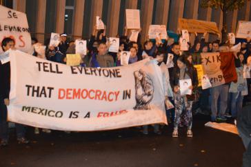 Protestaktion vor der mexikanischen Botschaft in Berlin. Auf dem Transparent: "Erzähl allen: Demokratie in Mexiko ist ein Betrug"