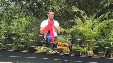 Leopoldo López zeigt sich den Medien und seinen Anhängern über der Mauer seines Anwesens in Venezuela, wo er unter Hausarrest steht