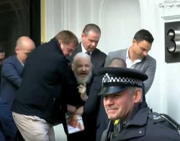Julian Assange bei seiner Festnahme in der ecuadorianischen Botschaft in London durch britische Polizisten