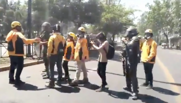 Mitarbeiter des Institutes für Menschenrechte – in gelben Jacken – vermitteln zwischen Polizei und Demonstranten
