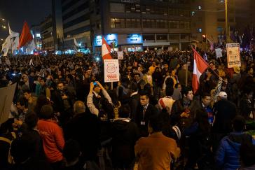 Demonstrierende in Lima. Jemand hält ein Schild mit dem Spruch "Que se vayan todos" hoch.