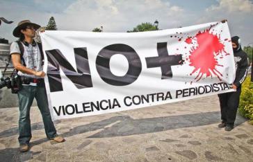 Männer halten Banner gegen die Gewalt an Journalisten