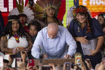 Ministerin Guajajara (li.), Präsident Lula und Funai-Präsidentin Wapichana im Camp. Lula unterzeichnete ein Dekret zur Demarkierung von sechs indigenen Territorien