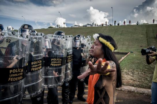 Indigene Frau vor Angehörigen der Militärpolizei